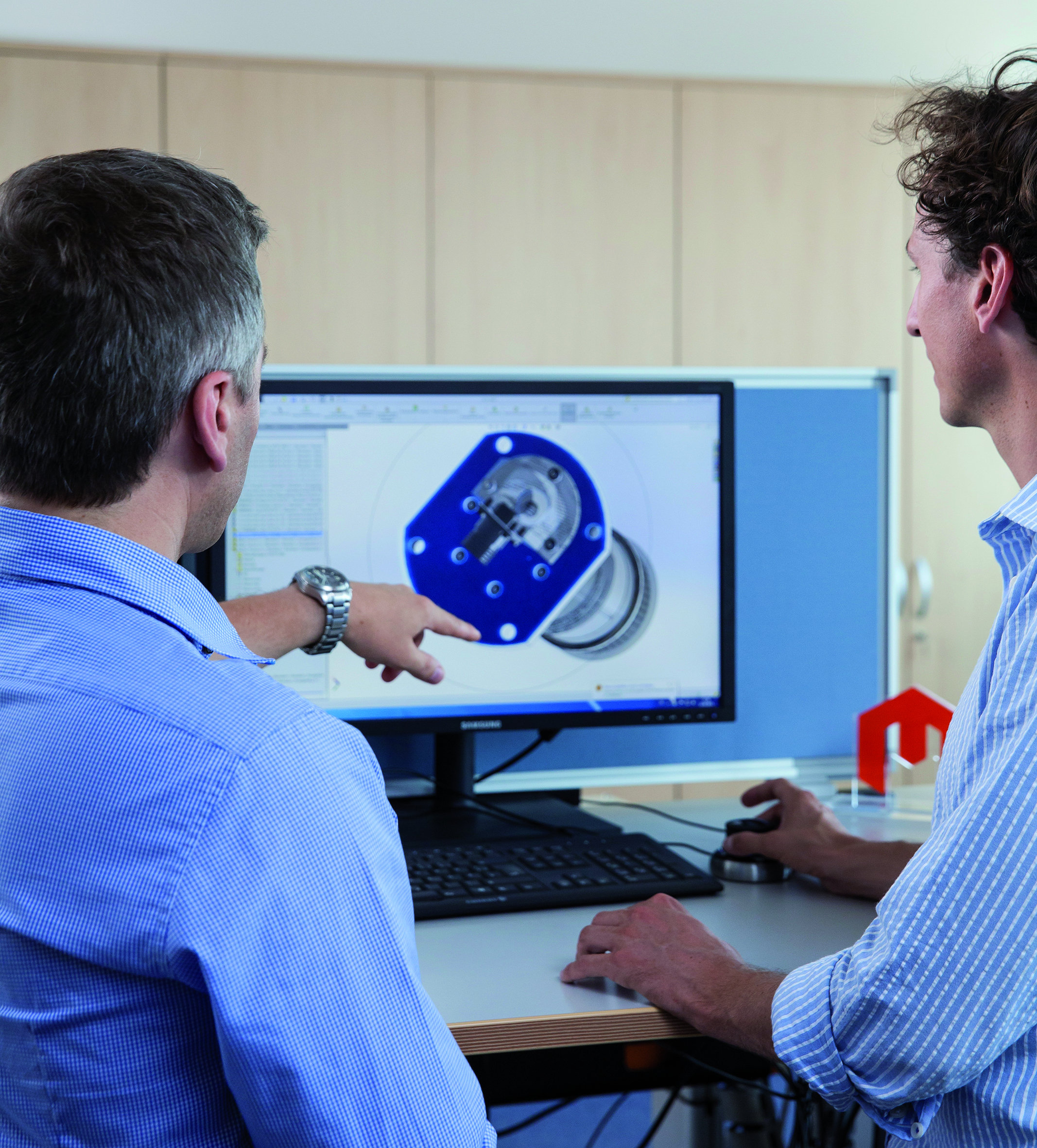Two men analysing NFMS product on computer