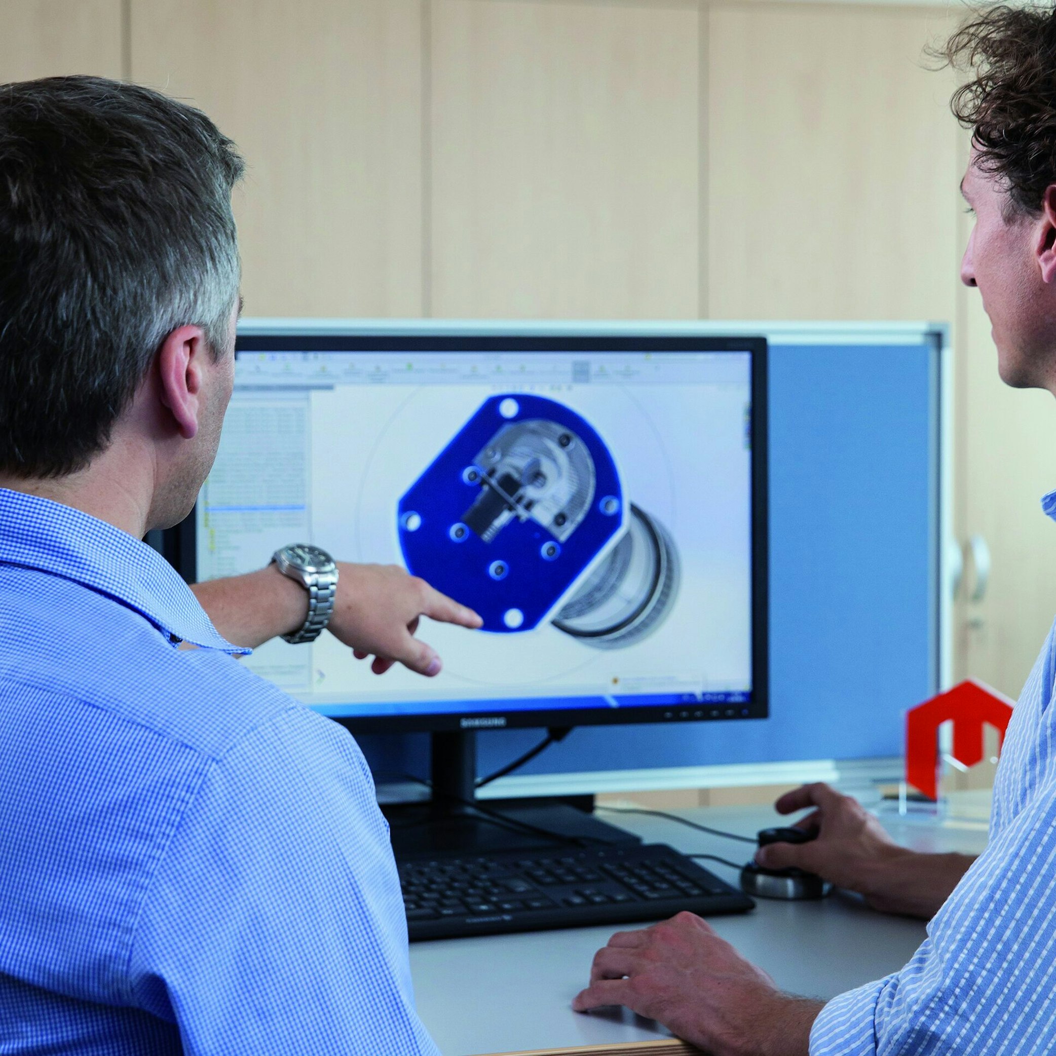 Two men analysing NFMS product on computer