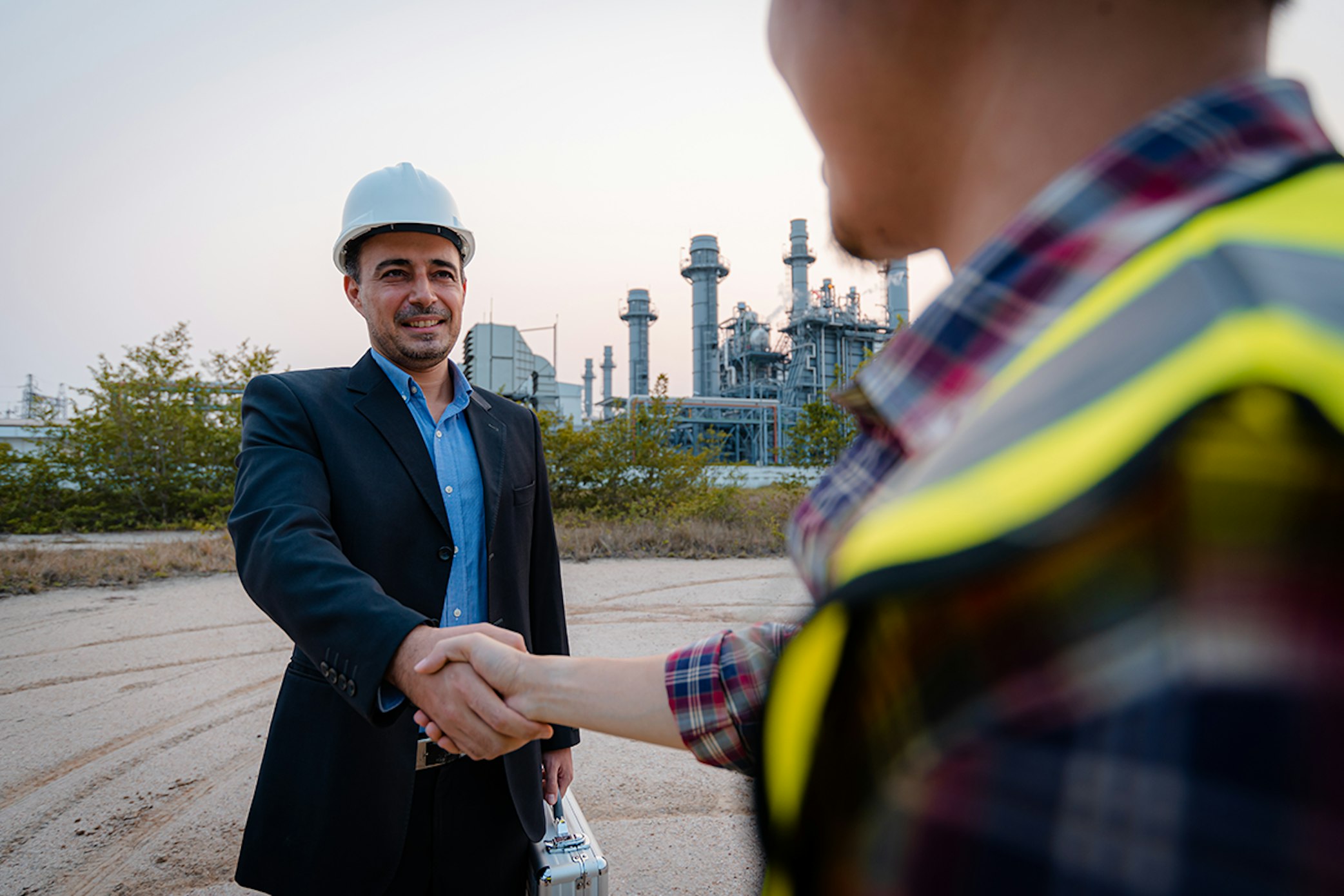 Man in suit shaking hands with worker