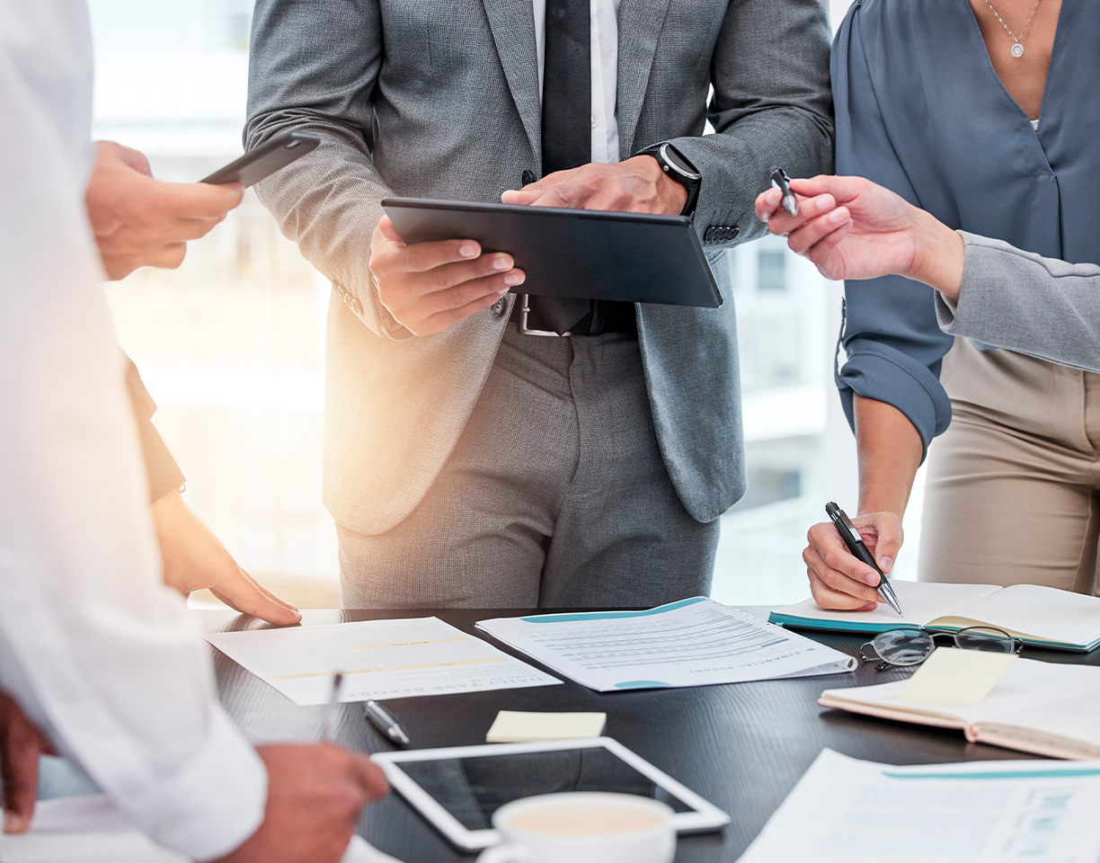Employees standing around table working
