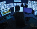 Unified aim scs interface man reviewing computer screens